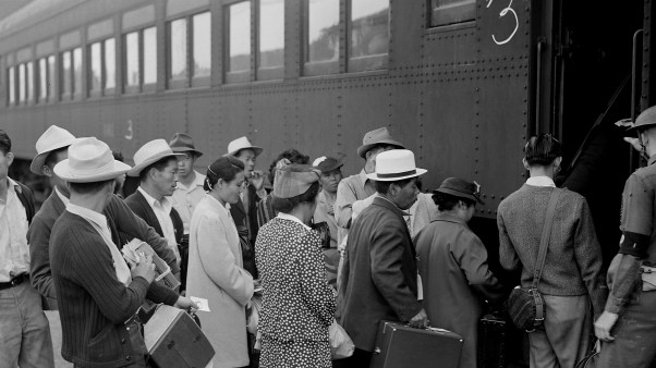 Evacuees of Japanese ancestry in Woodland, California, board a train for Merced Assembly center.