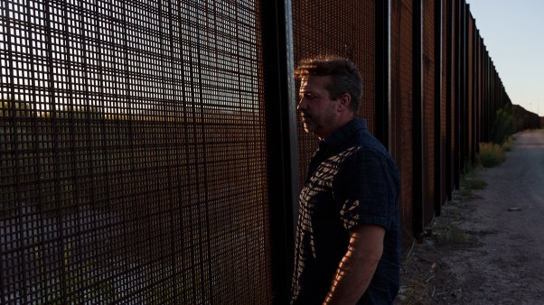 Sami DiPasquale looks through the fence along the US-Mexico border in El Paso, Texas.
