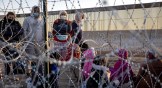 Immigrants wait to be processed by US Border Patrol agents at an encampment near the US-Mexico border.