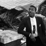 Reverend Shuttlesworth stands outside the wreckage of his house in December 1956, following an assassination attempt involving sixteen sticks of dynamite.