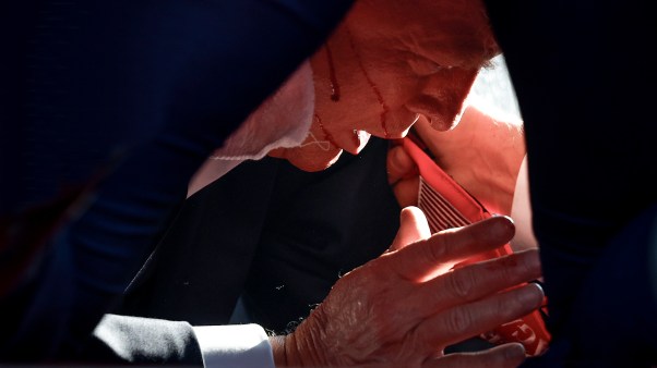 Former President Donald Trump is covered by U.S. Secret Service agents after an assassination attempt during a rally in Pennsylvania.