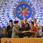 In Manila, Philippine government leaders sign peace accords with Moro rebel group.