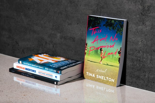 Photograph of "This ain't no promised land" book leaning against a concrete wall next to a stack of books