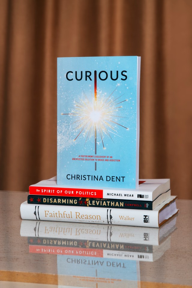 Photograph of "Curious" book on a stack of books with a orange background
