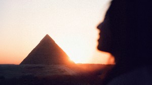 The shadow of a woman's face in front of an Egyptian pyramid