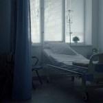 An empty hospital bed in a dark room