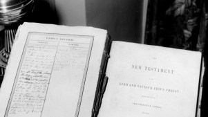 A vintage photo of a Bible with a genealogy written on the front page.
