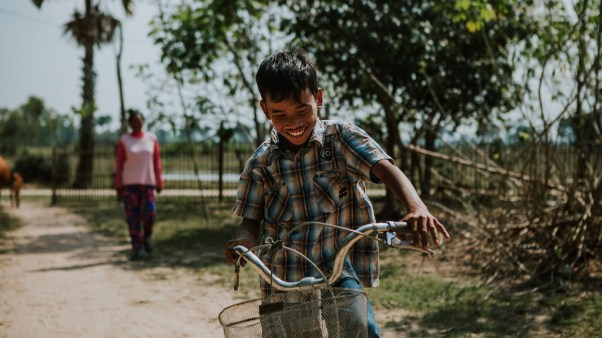 A foster child riding his bike in Cambodia