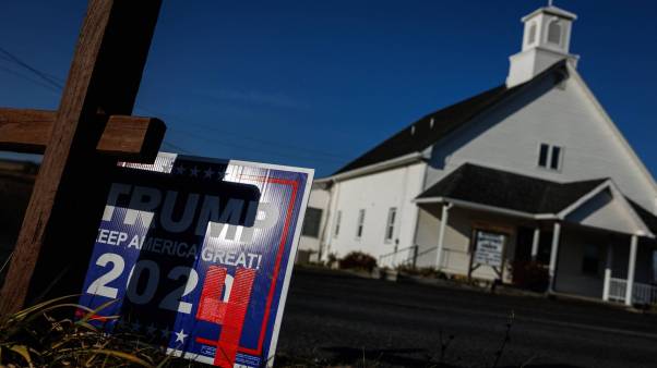 Trump 2024 campaign sign in front of a church with a cross