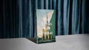A photo of Gavin Ortlund's book on a blue curtain background