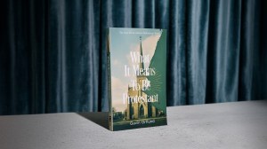 A photo of Gavin Ortlund's book on a blue curtain background