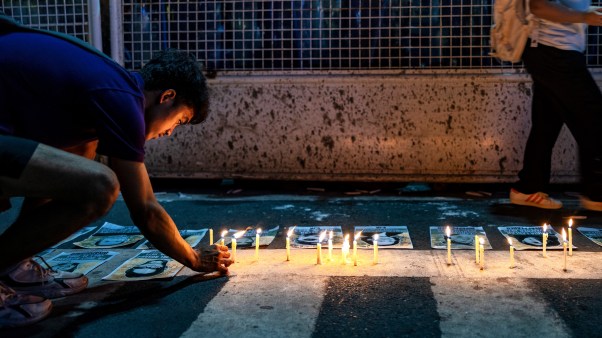 A Filipino activist lights candles to remember victims of martial law in the Philippines.
