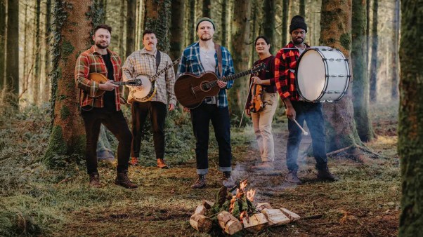 Rend Collective standing with instruments in the forest
