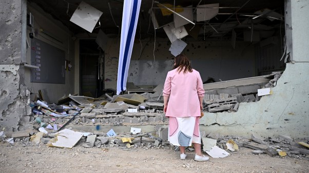 A woman standing in front of a ruined building in Israel.