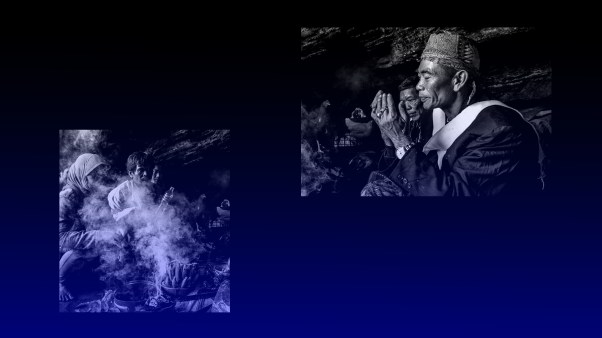 People sitting in smoke with a shaman praying