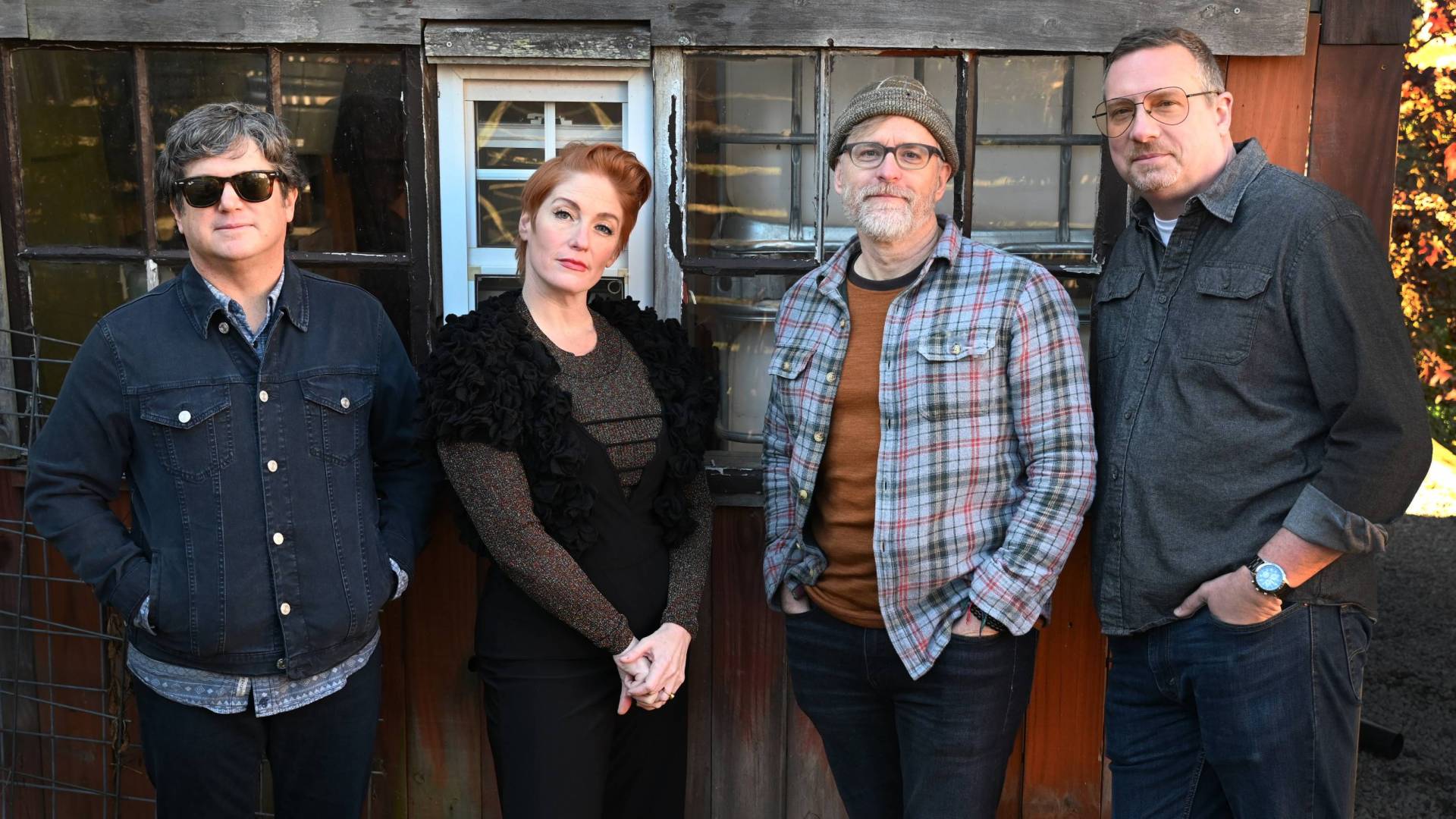 Four members of Sixpence None the Richer, including Leigh Nash, pose for a portrait in front of a barn.