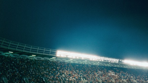 A stadium full of people at night with bright lights